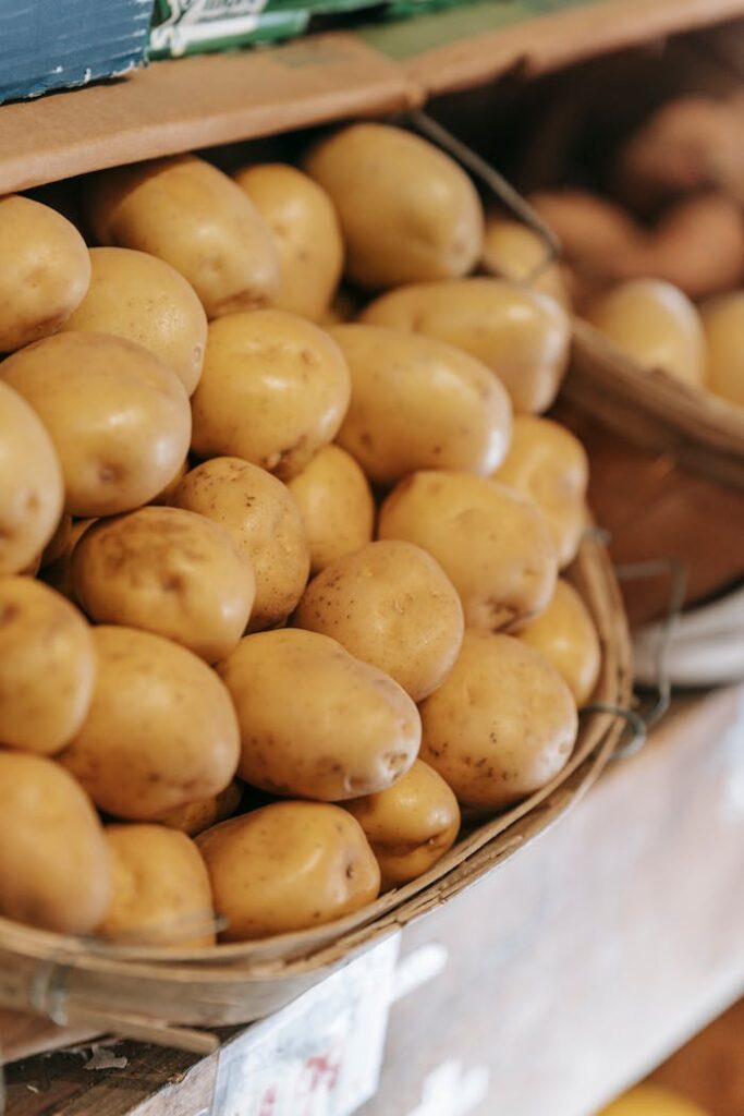 Rustic baskets filled with fresh potatoes at a local market stall, highlighting raw, healthy produce.